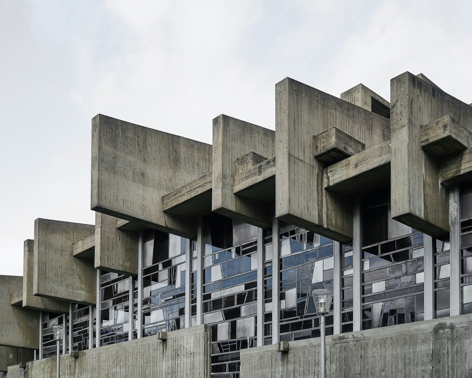 白い空の下に立つ立体的なコンクリート建築